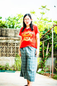 Portrait of woman standing against wall