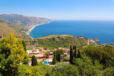 High angle view of townscape by sea against sky