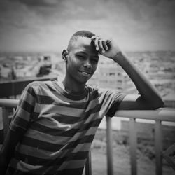 Portrait of teenage boy standing at railing