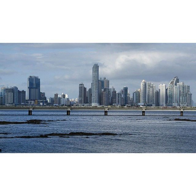 architecture, building exterior, city, built structure, skyscraper, sky, cityscape, urban skyline, water, skyline, river, tower, office building, tall - high, modern, cloud - sky, auto post production filter, financial district, transfer print, waterfront