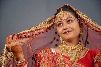 Close-up of smiling young bride standing against wall