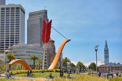 People at park against sky in city