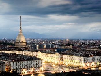 View of cityscape against cloudy sky