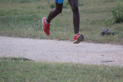 Low section of person running on field