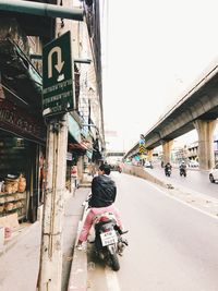 People riding bicycle on road in city