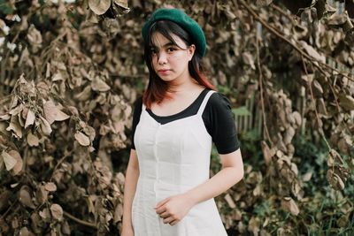 Portrait of beautiful young woman standing on land