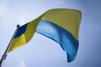 Low angle view of ukranian flag against blue sky