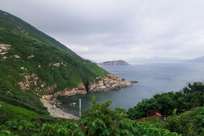 Scenic view of sea and mountains against sky