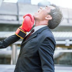 Cropped hand punching businessman in city