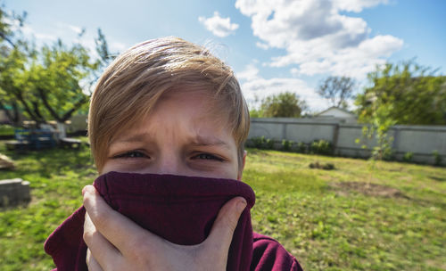 Close-up portrait of boy covering face