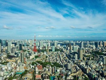 High angle view of city buildings against cloudy sky