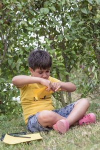 Portrait of boy sitting on field