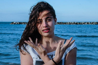 Portrait of beautiful woman at beach against sky