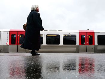 Full length of young woman standing by railing