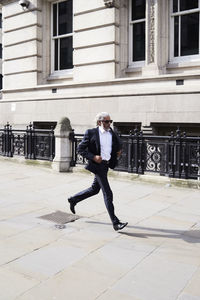 Senior businessman running on pavement in the morning