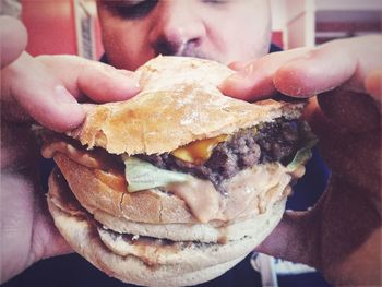 Close-up of man eating burger