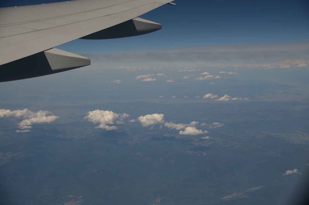 AERIAL VIEW OF AIRCRAFT WING OVER CLOUDS