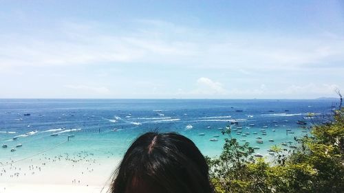 Rear view of woman on beach against sky
