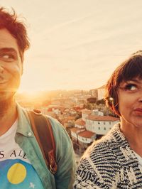 Portrait of smiling mid adult man in city against sky