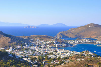 Aerial view of town by sea against clear sky