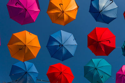 High angle view of umbrellas hanging against blue sky