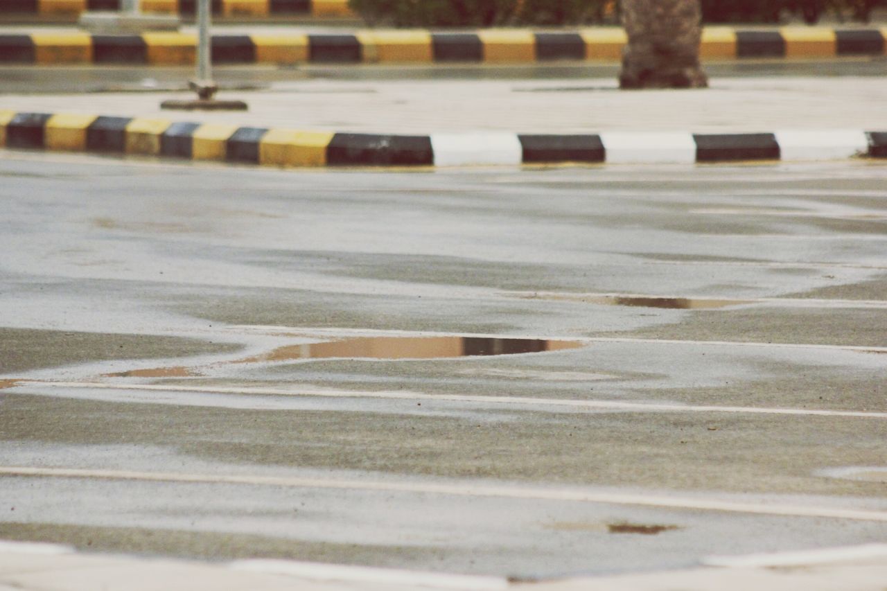 snow, road, street, winter, cold temperature, surface level, in a row, transportation, asphalt, weather, outdoors, empty, white color, day, season, road marking, no people, sand, focus on foreground, sunlight