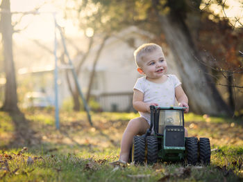 Portrait of cute baby boy sitting on toy vehicle