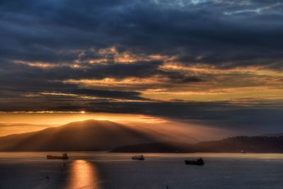 Scenic view of sea against dramatic sky during sunset