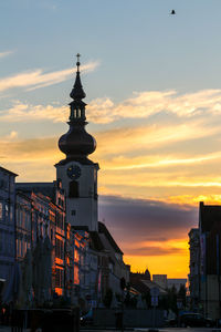 Buildings in city against sky during sunset