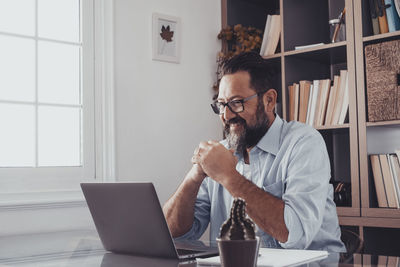 Man using mobile phone while sitting on table