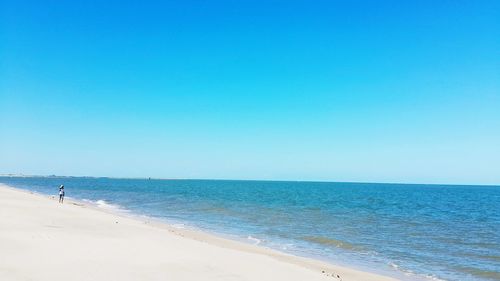 Scenic view of beach against clear blue sky