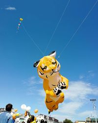 Low angle view of kite flying against blue sky