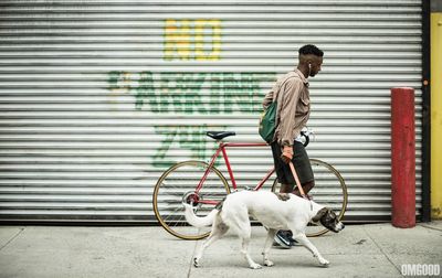 Full length of man with dog standing on bicycle