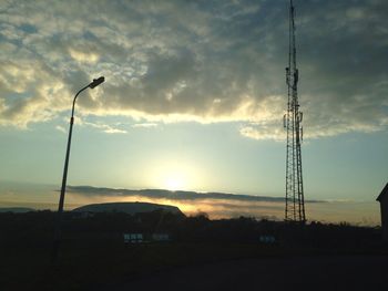 Scenic view of electricity pylon at sunset