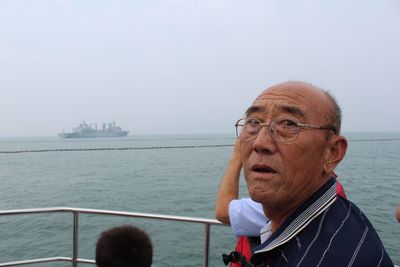 Portrait of senior man traveling in ship during foggy weather