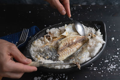 Midsection of person preparing food in cooking pan