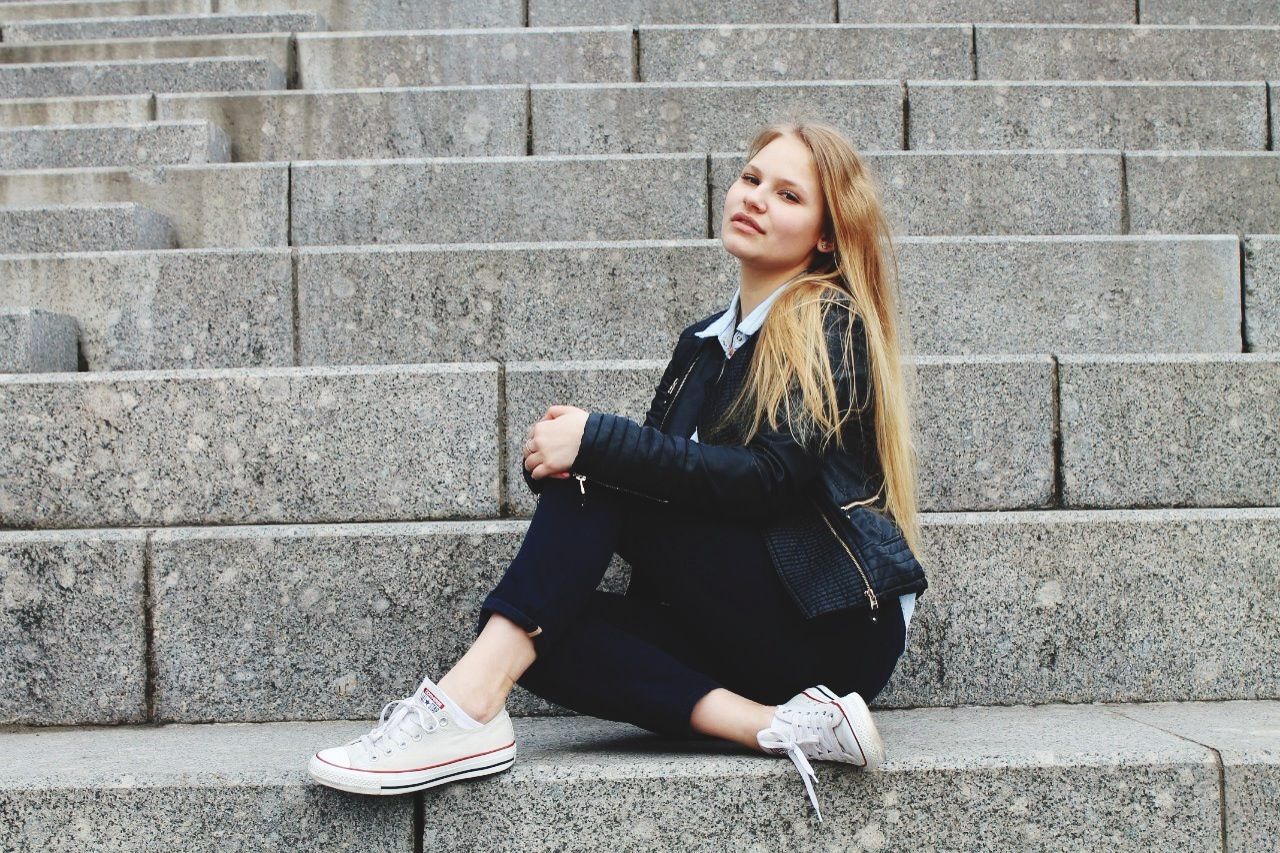 person, casual clothing, brick wall, lifestyles, young adult, portrait, looking at camera, front view, young women, standing, full length, wall - building feature, leisure activity, three quarter length, built structure, smiling, architecture