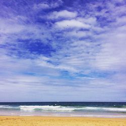 Scenic view of beach against cloudy sky