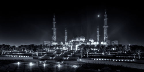 Illuminated buildings against sky at night