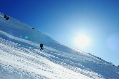 People skiing on snowcapped mountain against sky