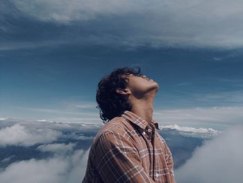 Man with head back against sky