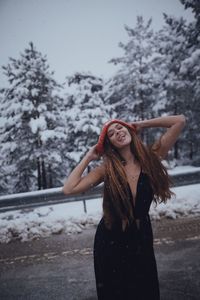 Young woman standing on snow covered tree