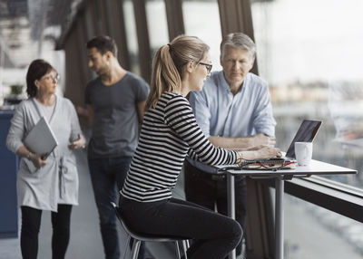 Business people working by window in office