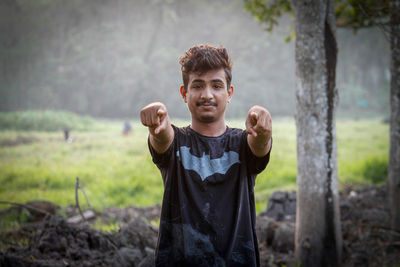 Portrait of young man standing on field