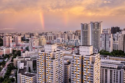 High angle view of modern buildings in city against sky during sunset