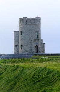 Old building on field against clear sky