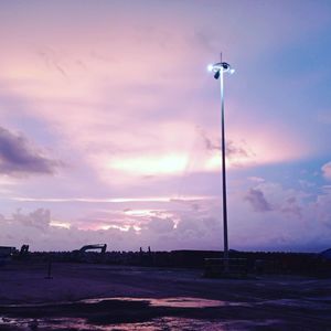 Street lights against dramatic sky during sunset