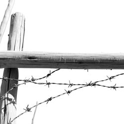 Low angle view of barbed wire against clear sky