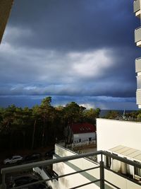 High angle view of swimming pool by building against sky