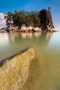 Scenic view of rock formation in water against sky